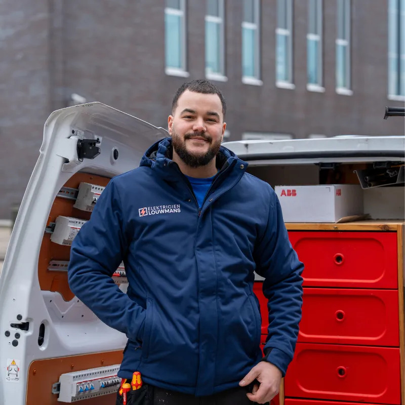 Elektricien van Louwmans bij de geopende bedrijfsbus met installatiemateriaal