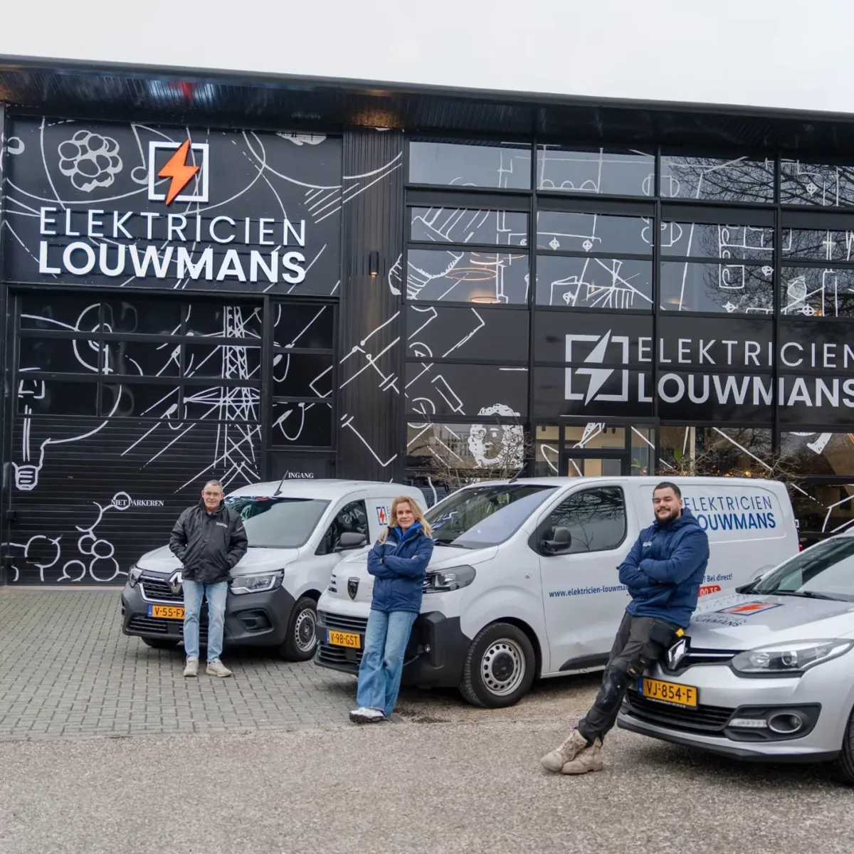 Medewerkers van Elektricien Louwmans bij het bedrijfspand en de bedrijfsauto's