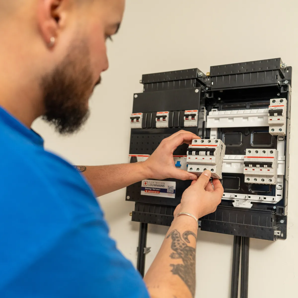 Elektricien plaatst een automaat in een groepenkast